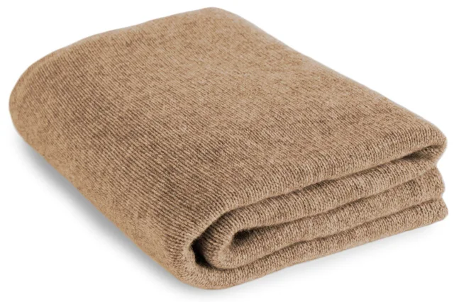 Natural cashmere bed and sofa throw, neatly folded.