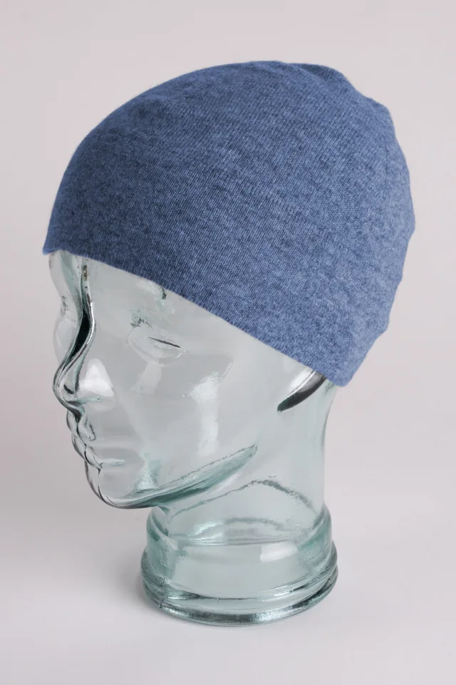 Denim blue cashmere watch cap shown on a display head.
